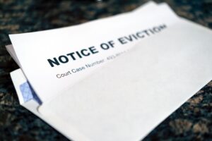 A rental agreement, envelope with past due notice, and keys sitting on a kitchen counter.