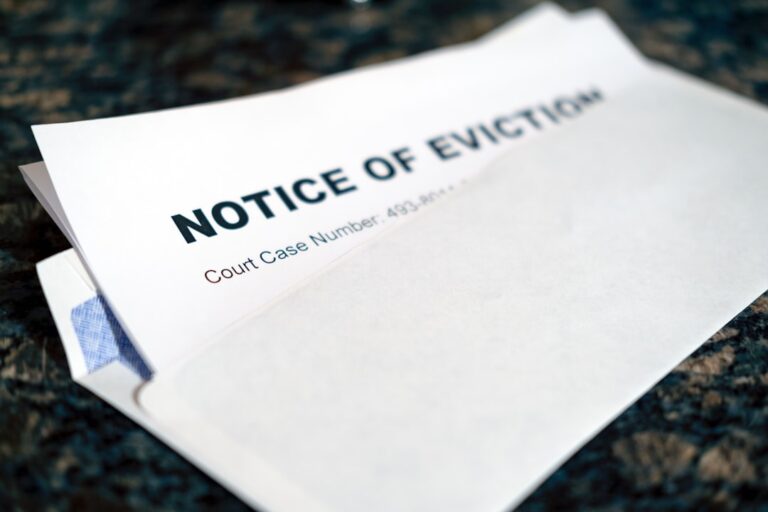 A rental agreement, envelope with past due notice, and keys sitting on a kitchen counter.