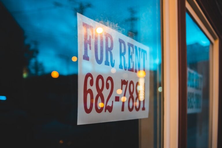 A landlord and prospective tenant sitting across a table reviewing a rental application together.