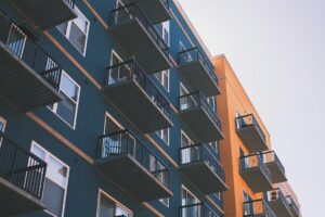 A property manager reviews a rental application with a resident at a desk beside housing forms and an accessibility checklist.